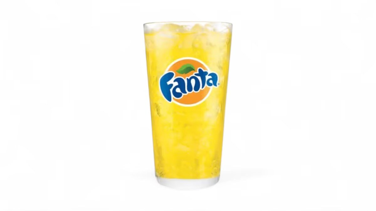 Fanta orange in a branded glass with ice