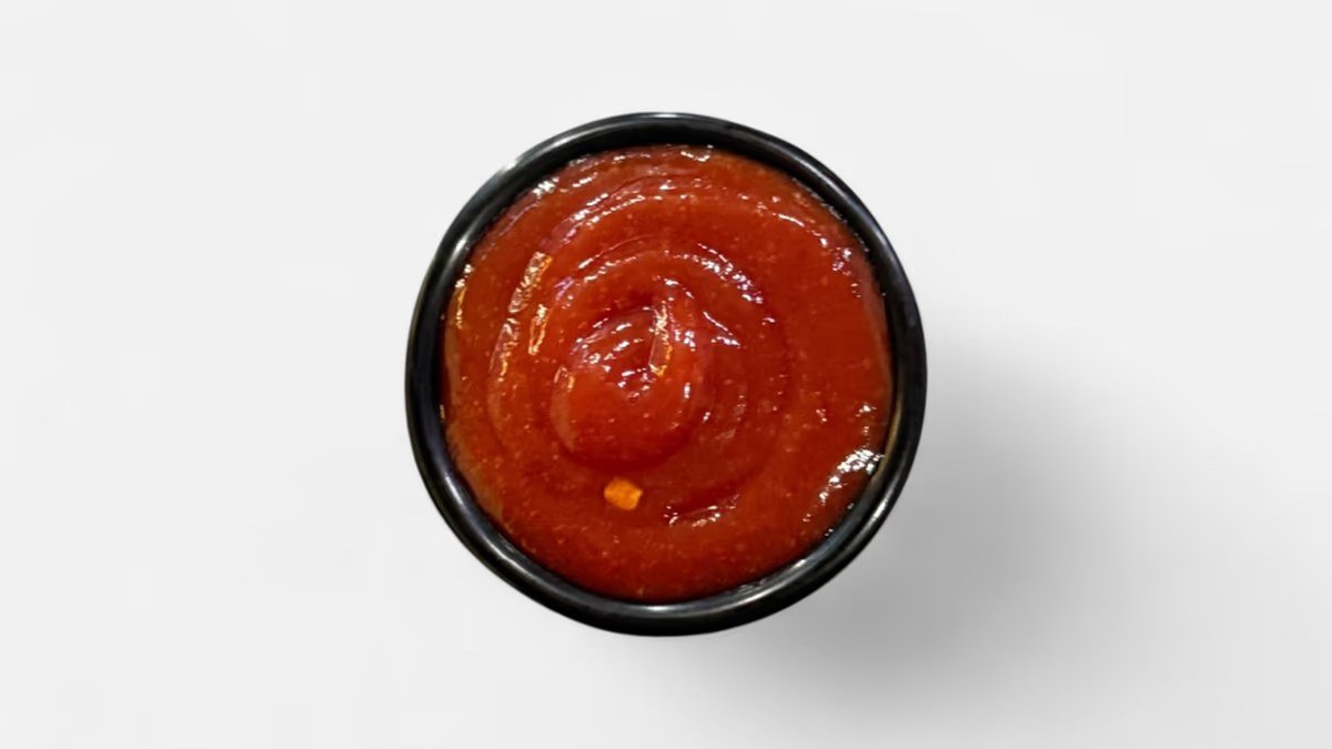 Sweet chili ketchup in a black ramekin